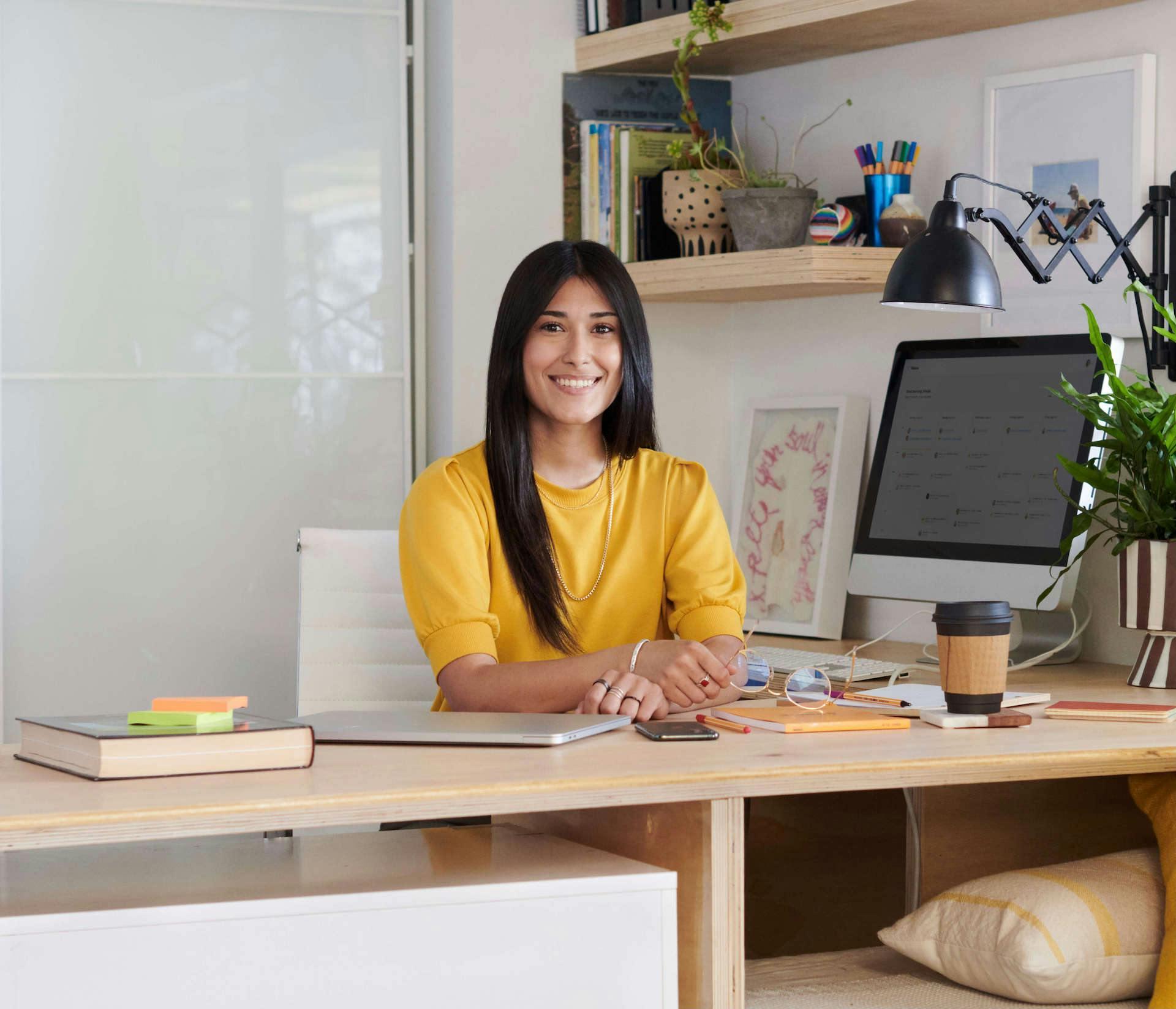 Smiling personal assistant sits at her desk