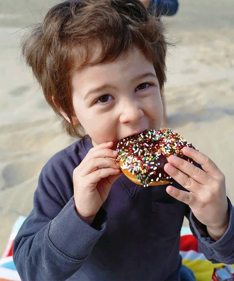 Young boy eats a donut