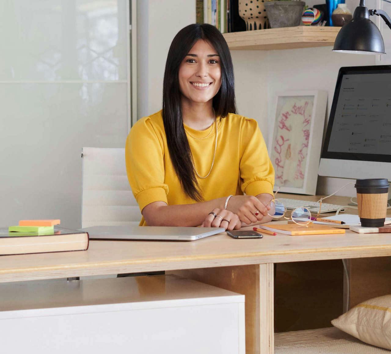 Smiling personal assistant sits at her desk